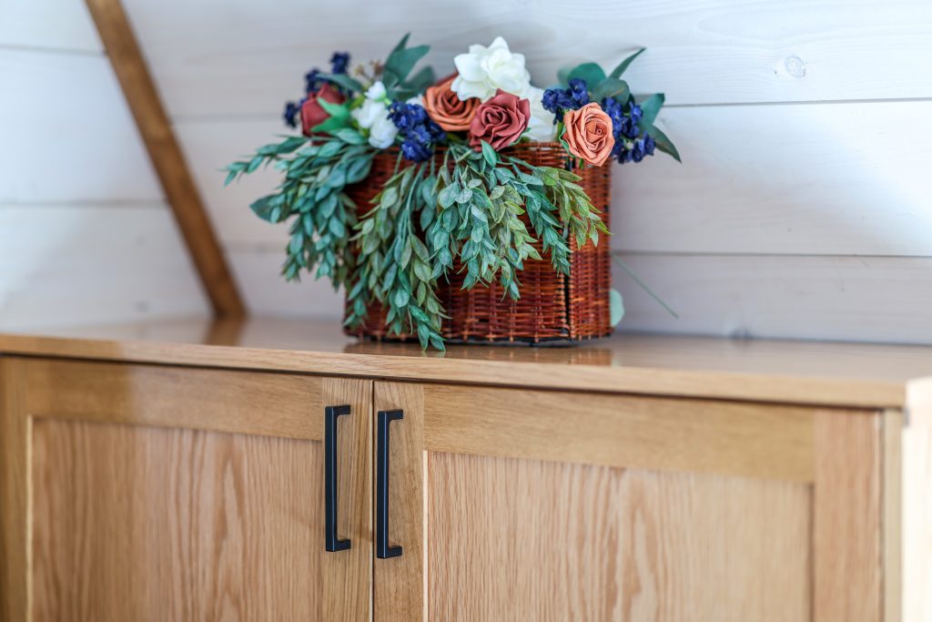 Basket with flowers on a cabinet top.